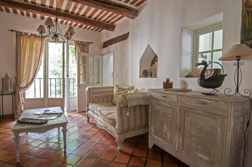 ein Wohnzimmer mit Sofa und Tisch in der Unterkunft La Marisol in LʼIsle-sur-la-Sorgue