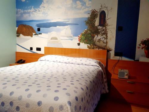 a bedroom with a bed and a painting of a ship at Motel Acropolis in Camponaraya