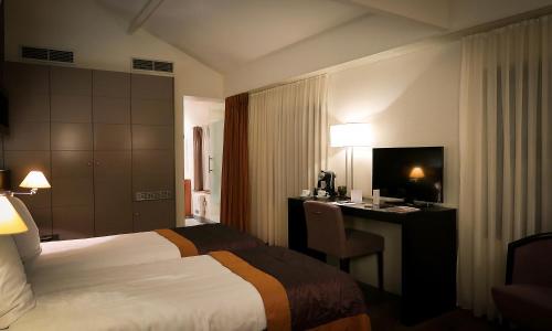 a hotel room with a bed and a desk at Hotel Van Eyck in Maaseik