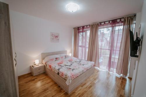 een slaapkamer met een bed en een groot raam bij Bella's Sea apartment-Beach, Sea garden ,Old Town, Free Parking, Free EVcharging Station in Varna