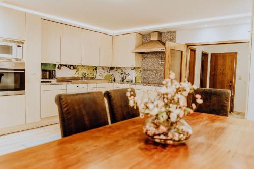a kitchen with a table with a vase of flowers on it at Ferienwohnung-lenne-Finnentrop in Finnentrop