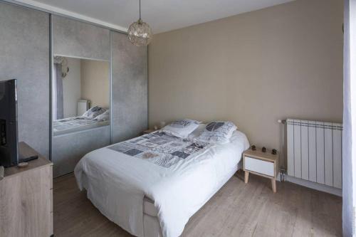 une chambre avec un grand lit et un miroir dans l'établissement Appartement T2 proche centre ville, à Istres