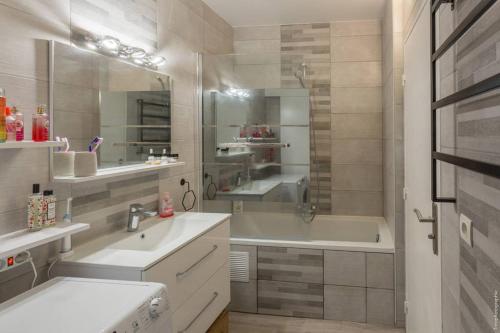 uma casa de banho com uma banheira, um lavatório e um chuveiro em Appartement T2 proche centre ville em Istres