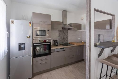 a kitchen with a stainless steel refrigerator and a sink at Appartement T2 proche centre ville in Istres