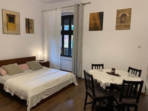 a bedroom with a bed and a table and a window at Kamienica na Krakowskiej 120 m2 in Tarnowskie Góry