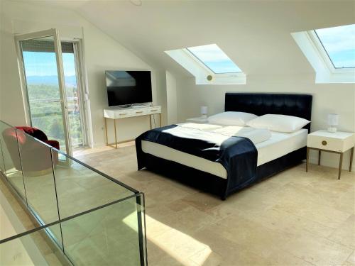 a bedroom with a bed and a tv and a window at Villa M - Your business & holiday apartment in Sibenik in Šibenik