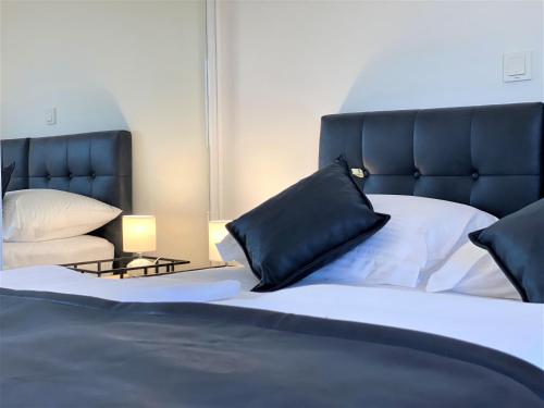 a bedroom with a large bed with a black headboard at Villa M - Your business & holiday apartment in Sibenik in Šibenik