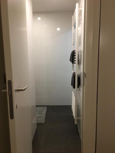 a bathroom with a hallway with a shower and a door at Villa van Brienen - Studio in Dilsen-Stokkem