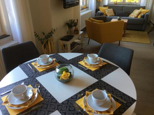 a table with plates and cups and bowls on top of it at Villa van Brienen - Studio in Dilsen-Stokkem