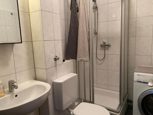 a bathroom with a toilet and a sink and a shower at Moderne Wohnung bei Duisburg Hbf. in Duisburg