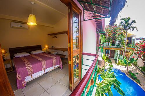 a bedroom with a bed and a balcony at Pousada da Banda in São Sebastião