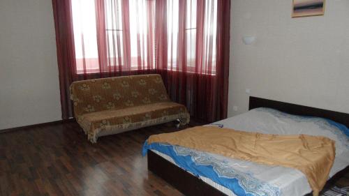 ノヴォロシースクにあるУЮТНАЯのベッドルーム1室(ベッド1台、椅子、窓付)