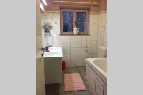 ein Badezimmer mit einem Waschbecken, einer Badewanne, einem Waschbecken und einem Spiegel in der Unterkunft Villa Vintage in Durbuy
