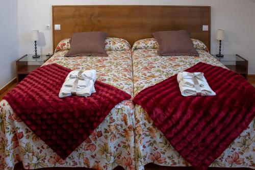 Una cama con dos pares de zapatillas. en Casa Terán, en Oviñana