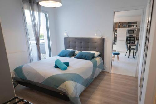 een slaapkamer met een groot bed met blauwe kussens bij Le Golfe du Morbihan et ses sentiers côtiers in Vannes