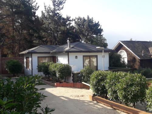 a white house with trees and a driveway at AmbienteMar Cabañas in Papudo