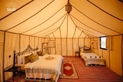 Tassili Luxury Desert Camp tesisinde bir odada yatak veya yataklar