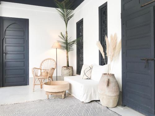 - un salon avec des portes noires et un canapé blanc dans l'établissement Riad Dar-K, à Marrakech