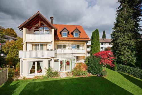 a large house with an orange roof on a yard at Kneipp-Kurhotel Steinle in Bad Wörishofen