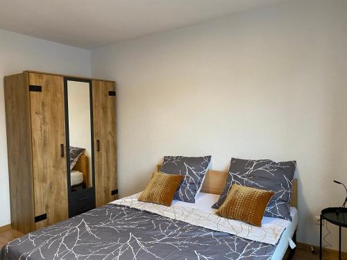 een slaapkamer met een bed met 2 kussens en een spiegel bij Moderne Wohnung bei Duisburg Hbf. in Duisburg
