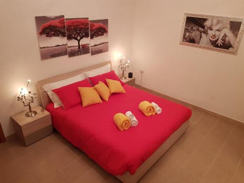 een slaapkamer met een rood bed met twee teddyberen erop bij LA MAISON - CRISPIANO in Crispiano