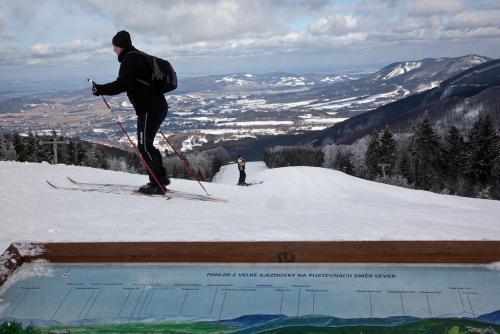 a man on skis standing on top of a mountain at Koliba Valaška in Trojanovice