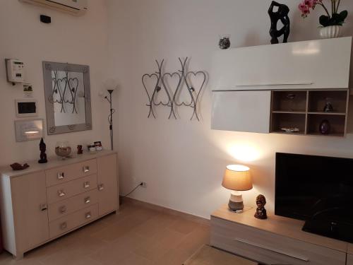 een woonkamer met een dressoir en een flatscreen-tv bij LA MAISON - CRISPIANO in Crispiano
