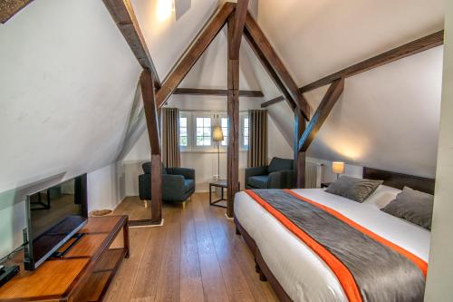 a bedroom with a bed and a tv in a room at La Villa Du Coteau in Obernai