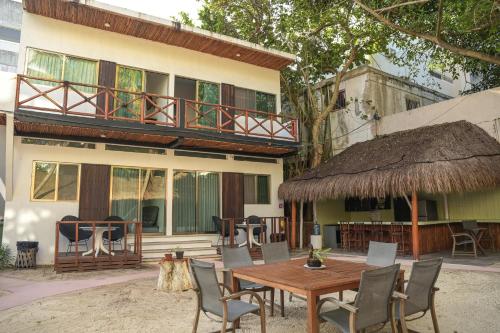 a patio with a table and chairs and a building at Kinta Kan Cabañas Hotel Playa del Carmen in Playa del Carmen