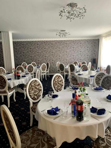 a dining room with white tables and chairs at Sinay Hotel & Restaurant in Chechel'nyk
