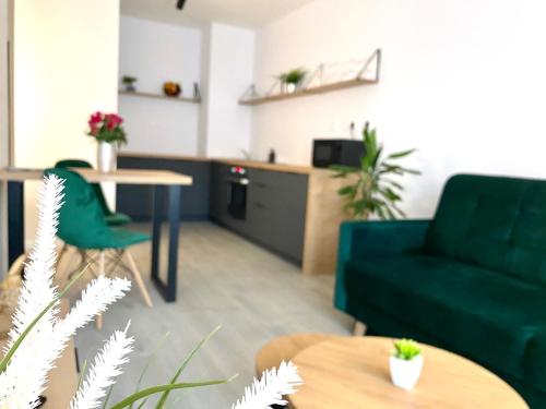 a living room with a green couch and a table at Apartment Malá Praha in Žilina