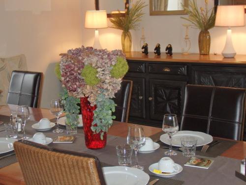 a table with a vase of flowers on top of it at Chambres d'Hôtes Le Tilleul in Saint-Hilaire-des-Loges