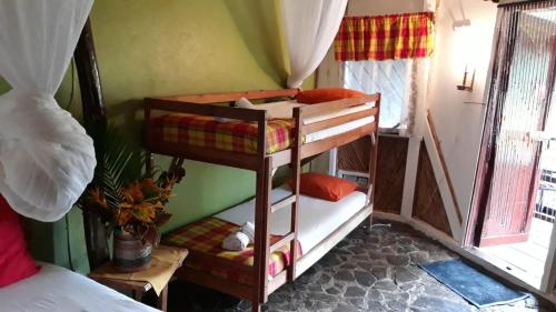 a bedroom with two bunk beds in a room at Hibiscus Valley Inn in Marigot