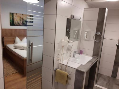 a bathroom with a sink and a bed in a room at Gasthaus Gonnermann in Sontra