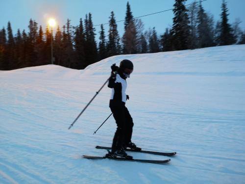 a person is skiing down a snow covered slope at Villa Björklund - Lakeview Apartment in Arjeplog