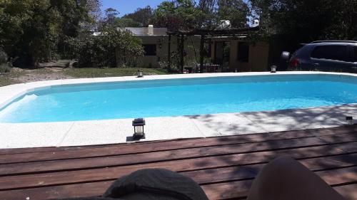 a swimming pool with blue water in a yard at Los Mochos Portezuelo in Punta del Este