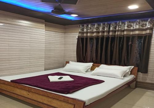 a bedroom with a large bed with a purple blanket at Hotel Raahat Palace in Ajmer