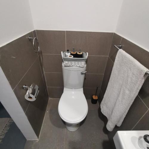 a bathroom with a toilet and a sink and towels at The Beach Hide in East London
