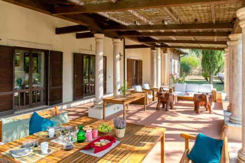 an outdoor patio with wooden tables and chairs at Villa Il Turchetto in Manciano