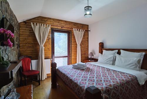 a bedroom with a bed and a window at Cabana Zimbru Transfagarasan in Arefu