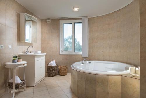 a large bathroom with a tub and a sink at Вила Франк/Villa Frank in Enina