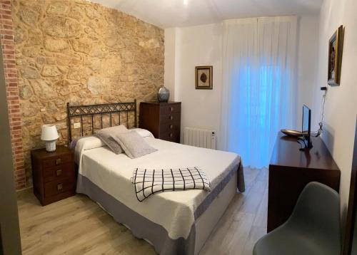 a bedroom with a bed and a desk and a chair at CASA SAN JURJO in Finisterre