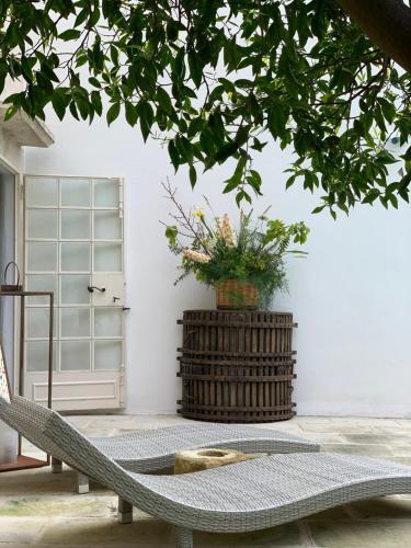 a rattan chair in front of a white wall at Palazzo Castriota in Alezio