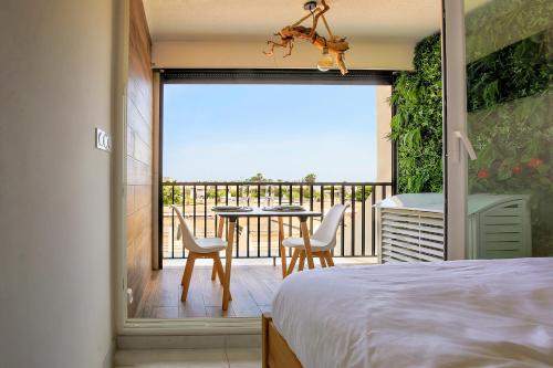 - une chambre avec un balcon doté d'une table et de chaises dans l'établissement Joli appartement village naturiste, au Cap d'Agde