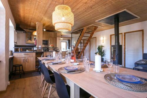 une longue table en bois avec des assiettes et des verres dessus dans l'établissement Chalet Iseran, à Bourg-Saint-Maurice