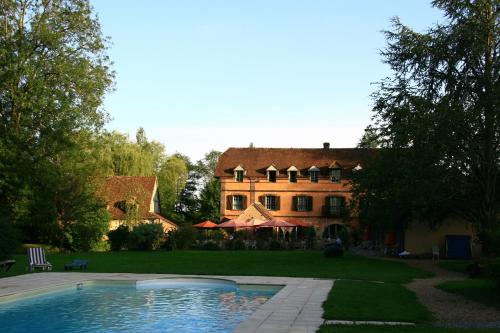 une grande maison avec une piscine devant dans l'établissement Domaine De Villeray, à Condeau