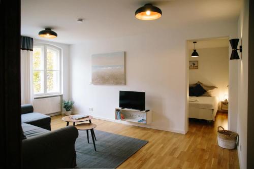 a living room with a couch and a tv at Madflats Hotel-Apartments S-Bahn Friedenau in Berlin