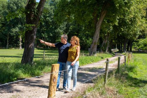 a man and a woman standing next to a fence at Boetiek Hotel BonAparte Lochem in Barchem