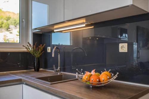 a kitchen with a bowl of fruit in a sink at Luxury Apartments Tafra in Lokva Rogoznica
