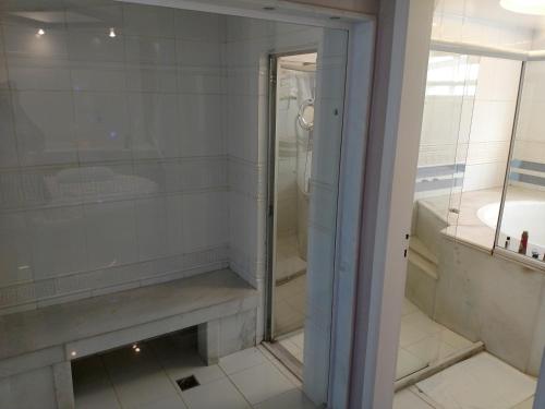 a glass shower in a bathroom with a sink at A2 suites - Hotel e Motel in Brasilia